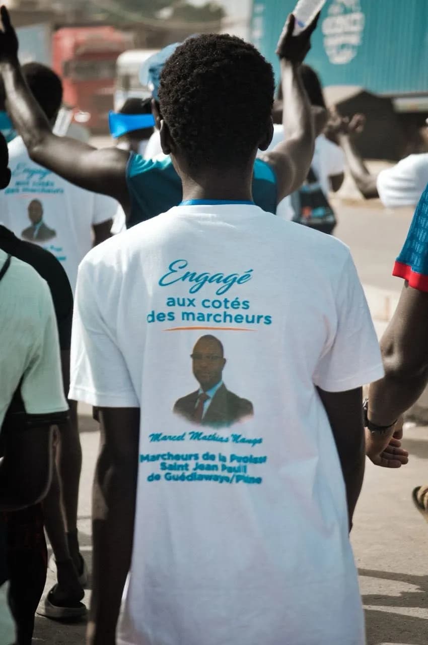 Des marcheurs portant un t-shirt de soutien lors d'une marche à Golf Sud